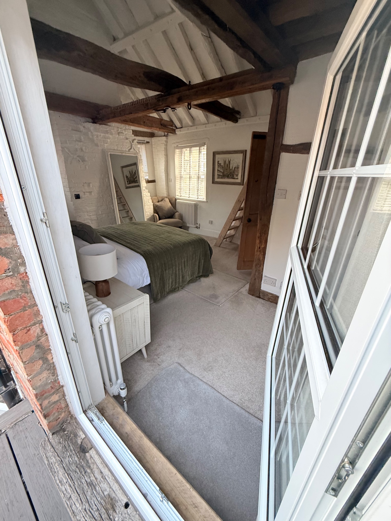 View from the balcony doorway into The Nook bedroom with exposed beams