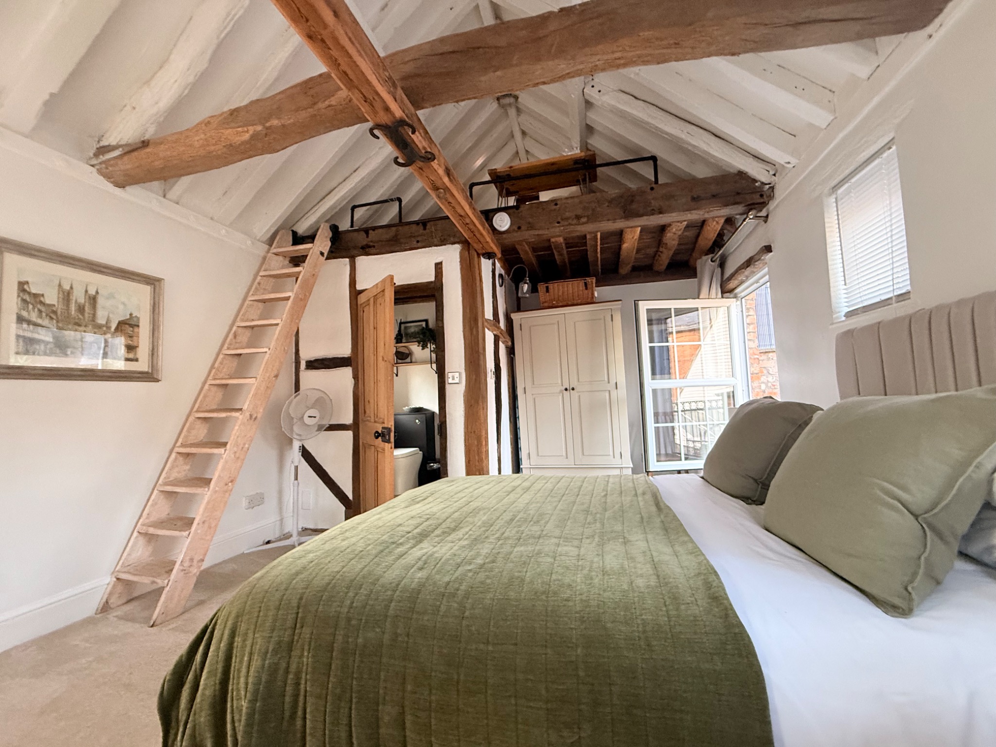 The Nook upstairs bedroom, exposed beams and mezzanine above